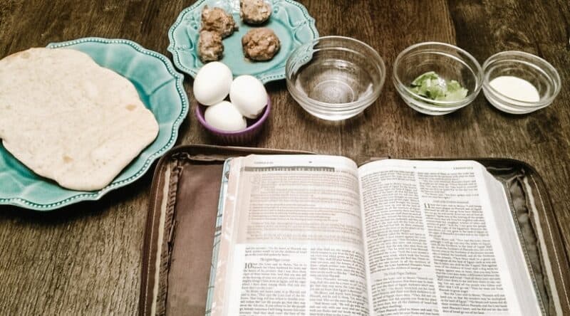 Image of an open Bible and a passover Seder meal- bread, meat, eggs, water, greens | 6 Special Christian Easter Activities for Families
