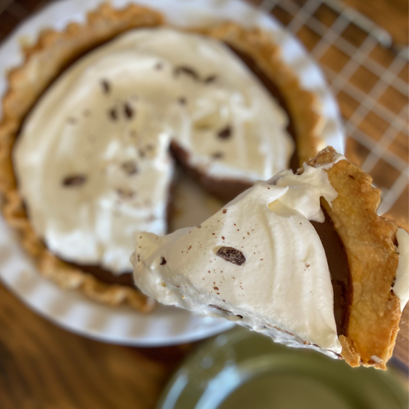 Chocolate pie slice held above the pie pan