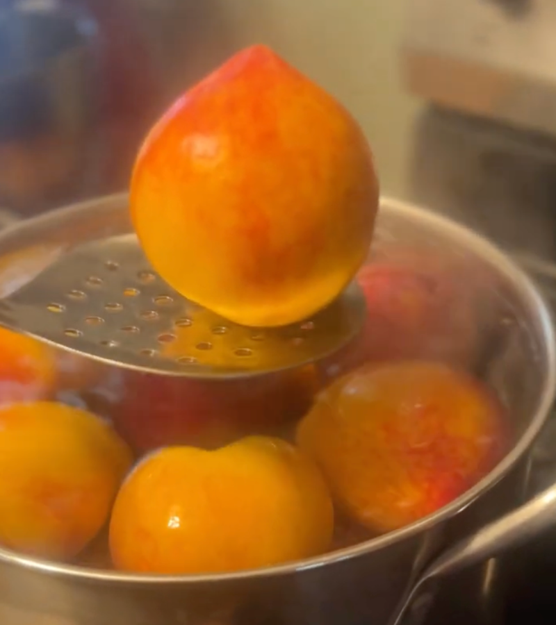 blanching peaches in a pot of boiling water