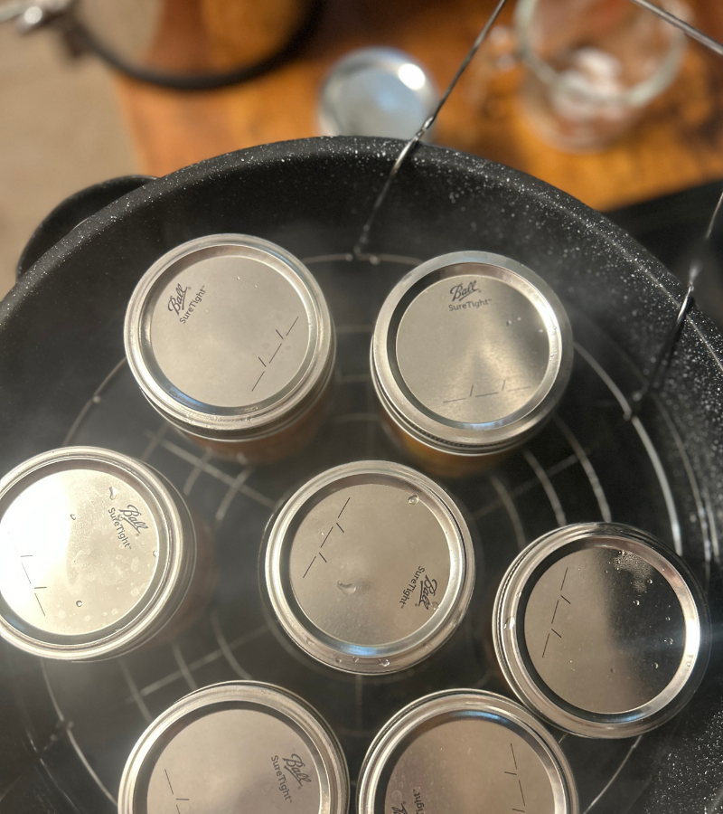 canning jars filled with peaches in a water bath canner | how to preserve peaches